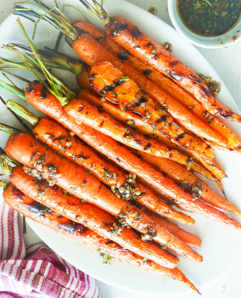 Grilled Carrots served in a white plate with brown butter sauce