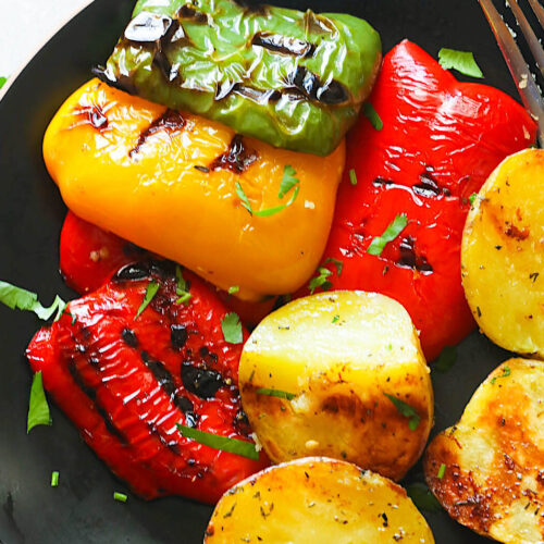 Grilled peppers and potatoes topped with fresh basil