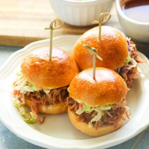 Delicious smoked pulled pork sliders served on soft buns, topped with tangy coleslaw and drizzled with savory barbecue sauce.