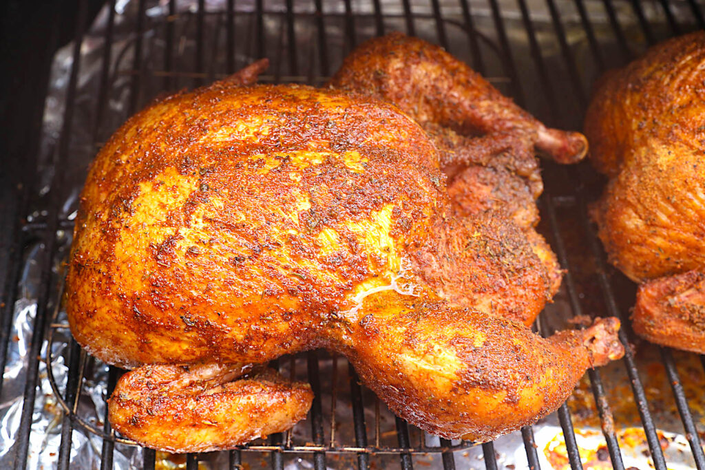 Smoked whole chicken ready to come out of the pellet grill and enjoy